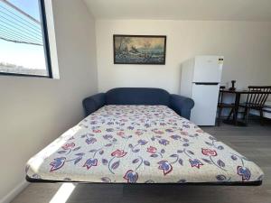 Bett in einem kleinen Zimmer mit Kühlschrank in der Unterkunft Claremont Comfort Cottage in Claremont