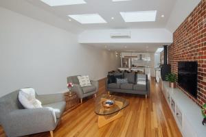 a living room with couches and a brick wall at SENSATIONAL Renovated Cottage in Beautiful Seddon in Seddon
