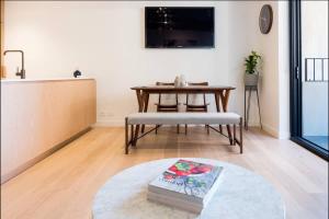 een woonkamer met een tafel en een bank en een keuken bij Cozy 2 Beds Apartment In Fitzroy For Rest And Work in Melbourne