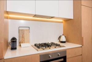 een keuken met een kookplaat en een oven bij Cozy 2 Beds Apartment In Fitzroy For Rest And Work in Melbourne