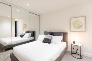 een slaapkamer met 2 bedden en een spiegel bij Cozy 2 Beds Apartment In Fitzroy For Rest And Work in Melbourne