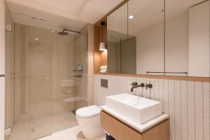 a bathroom with a sink and a toilet and a shower at Modern Apartment In Flawless Fitzroy+Carpark in Melbourne