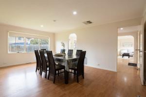 a dining room with a table and chairs at Cozy Family Friendly Werribee Home in Werribee