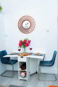 een witte tafel met een vaas met bloemen en een spiegel bij Stunning-Gated-Listed Stay-Park-Homestay-Retreat in Londen