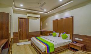 a bedroom with a large bed with green pillows at Treebo Bliss in Jaipur