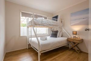 a bedroom with two bunk beds and a window at Cozy Family Friendly Werribee Home in Werribee