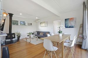 a living room with a table and chairs and a couch at The Starfish Cottage - 250m to bay beach in Rye