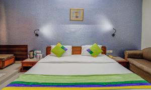 a bedroom with a large white bed and a couch at Treebo Bliss in Jaipur