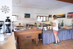 a woman standing at a counter in a kitchen at Feriendorf La Mora in Calvi