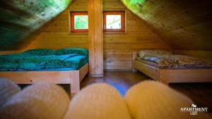 um quarto com 2 camas num chalé de madeira em Brunarica Vrhovc em Železniki