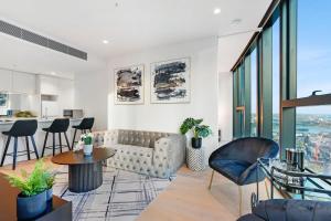 een woonkamer met een bank en een tafel en stoelen bij Southbank Luxury Millennial 2bdm Apt in the Clouds in Melbourne