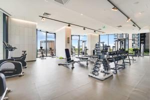 een fitnessruimte met loopbanden en cardio-apparatuur in een gebouw bij Southbank Luxury Millennial 2bdm Apt in the Clouds in Melbourne
