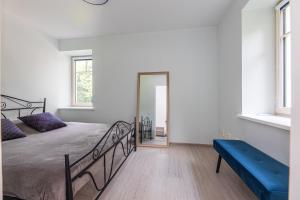 a bedroom with a bed and a blue bench at Seaside Apartments - Apartment by the sea in Klaipėda