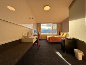 ein Zimmer mit einem Bett und einem Schreibtisch mit einem Computer in der Unterkunft Te Anau Manapouri Lake Hotel in Manapouri