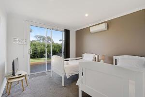 a bedroom with two beds and a tv and a window at The Dolphin Cottage - 250m to bay beach in Rye