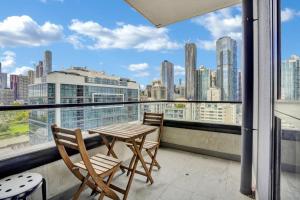 a balcony with a table and chairs and a view of the city at Central 15th floor Apt near Flagstaff & QV Market in Melbourne