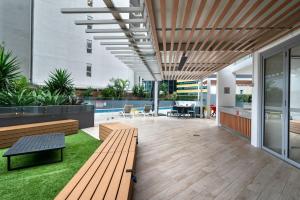 a patio with benches and a pool in a building at City Living - Brisbane River-View 2 bedroom Apt in Brisbane