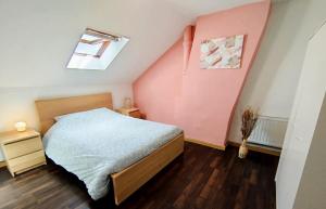 a bedroom with a bed and a pink wall at Révélation Liège in Liège