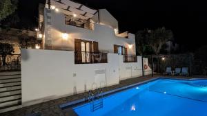 a villa with a swimming pool at night at Villa Koumos - Crete Holidays With Pool and Views in Gavalochori