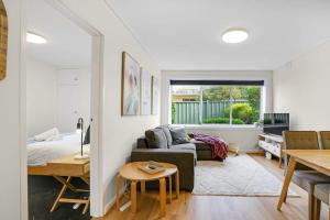 een woonkamer met een bank en een bed bij Homey 1 bdrm Thornbury Apt near restaurants+shops in Melbourne
