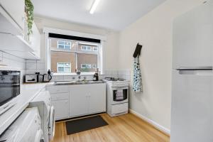 a kitchen with white appliances and a window at Homey 1 bdrm Thornbury Apt near restaurants+shops in Melbourne
