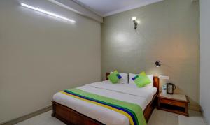 a bedroom with a large bed with green pillows at Treebo Bliss in Jaipur