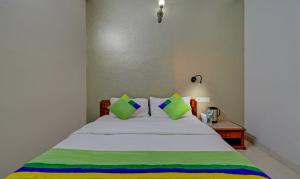 a bed with green and white sheets and pillows at Treebo Bliss in Jaipur