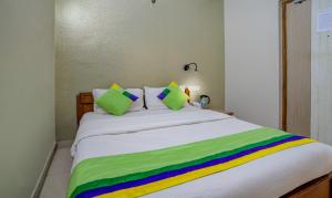 a bed with a rainbow colored blanket on it at Treebo Bliss in Jaipur