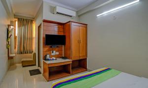 a bedroom with a bed and a desk with a television at Treebo Bliss in Jaipur
