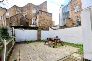 a picnic table in front of a brick building at 3 Bedroom Prime Angel Location in London