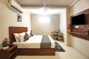 a bedroom with a bed and a flat screen tv at Limewood Stay Studio Huda City Center in Gurgaon
