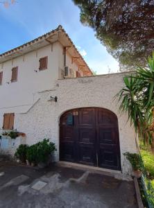 un garaje con una gran puerta de madera en Villa del Capitano, en SantʼAndrea