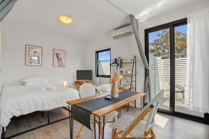 1 dormitorio con 1 cama, mesa y sillas en Perfect Box Hill High Studio Apartment w parking, en Burwood
