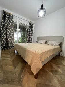 a bedroom with a bed and a large window at The Olives Terrace Residences in Dhërmi