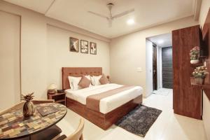 a bedroom with a bed and a table at Limewood Stay Studio Huda City Center in Gurgaon