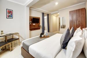 a bedroom with a bed and a desk and a television at Limewood Stay Studio Huda City Center in Gurgaon