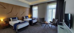 una camera d'albergo con due letti e una TV a schermo piatto di Hotel Austria & Bosna a Sarajevo