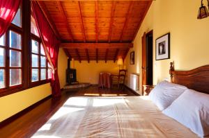 una camera con letto e soffitto in legno di Casa Angel Caldueño 