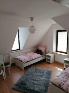 um quarto com uma cama, 2 janelas e um tapete em Wolke 7 em Freital