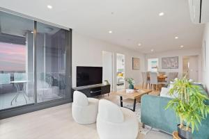 a living room with white furniture and a large window at Lv53 Spanning 200 degrees with no obstacle view421 in Melbourne