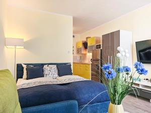 Un dormitorio con una cama azul y un jarrón con flores azules en visit baltic - Monte Cassino, en Świnoujście