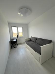 Jest to biały pokój z łóżkiem i biurkiem. w obiekcie Glazurowa apartament Trójmiasto w Gdańsku