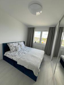 um quarto com uma cama e uma grande janela em Glazurowa apartament Trójmiasto em Gdansk