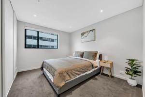 拉弗顿Prime 1BR Apt in Williams Landing w parking的一间带床和窗户的白色卧室