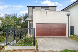 een huis met een garagedeur en een poort bij Bundoora Family Home near Uni Hill in Bundoora