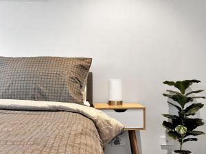 拉弗顿Prime 1BR Apt in Williams Landing w parking的配有枕头的床和植物床头柜