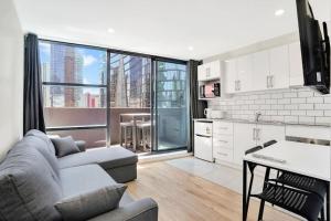 cocina y sala de estar con sofá y mesa en Gem in heart of Melbourne CBD, en Melbourne