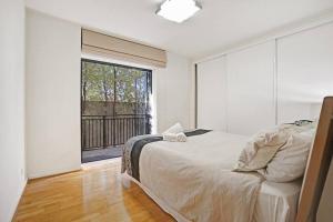 a bedroom with a bed and a large window at Humble Abode @Footscray (CBD Accessible) in Melbourne