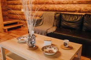a living room with a table with two cups and a couch at Brīvdienu māja Straumēni in Pāle