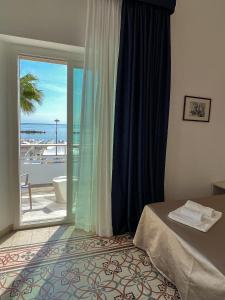 a bedroom with a window with a view of the ocean at Hotel Ideal in Cupra Marittima